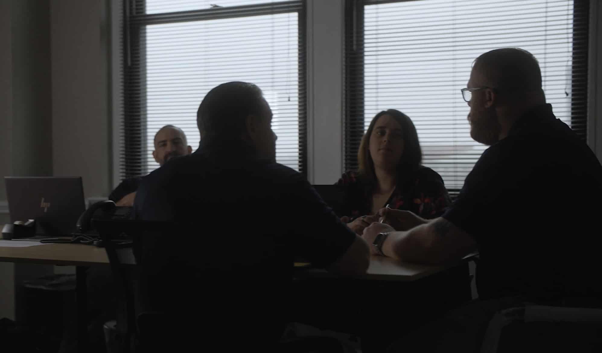 Corporate team seated around a table having a meeting.