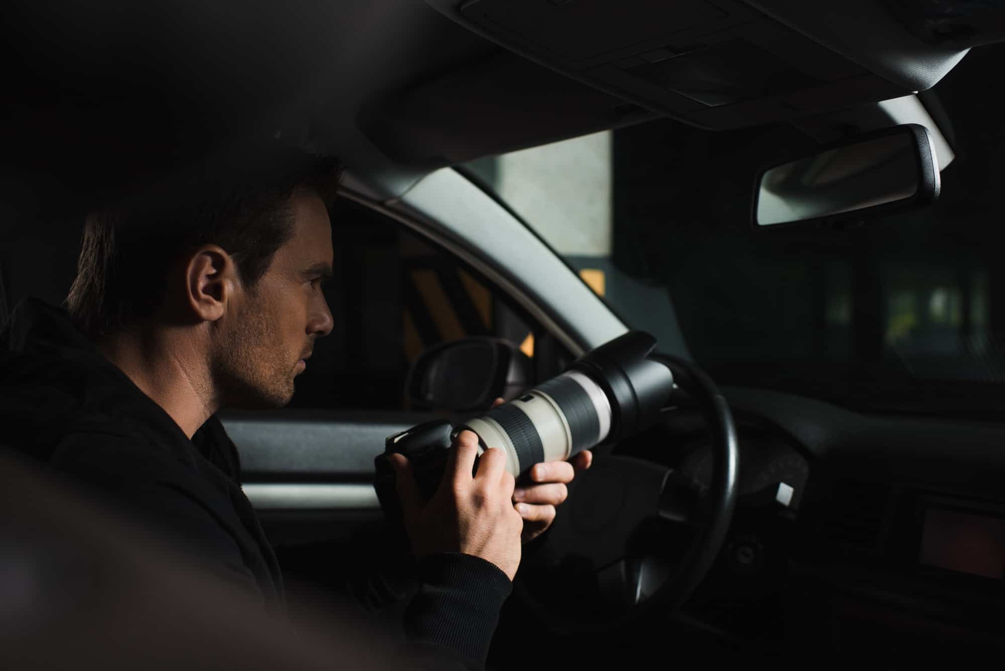 Surveillance photographer prepares his camera for a photo.